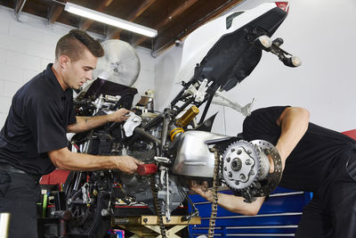 Workers making motorcycle in workshop