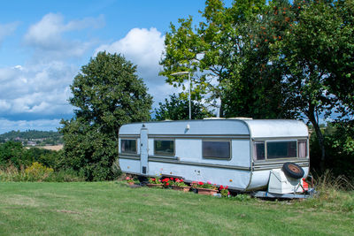 Caravan on field against sky