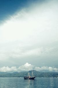 Sailboat sailing on sea against sky