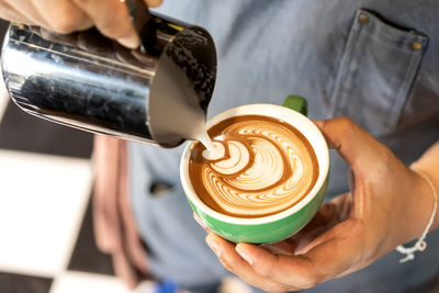 Cropped image of hand holding coffee cup