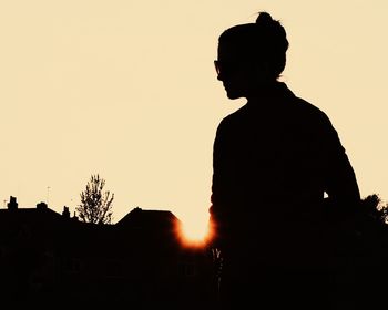 Silhouette man standing against clear sky during sunset