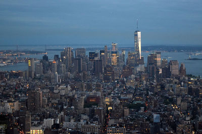 Cityscape by east river against sky at dusk