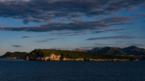 Scenic view of sea and mountains against sky