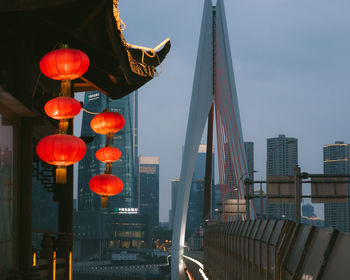 Illuminated lanterns hanging against sky in city