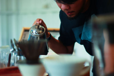 Close-up of man pouring coffee in cafe