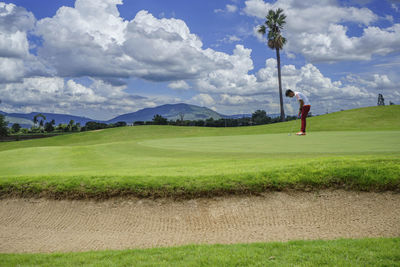 Scenic view of golf course against sky