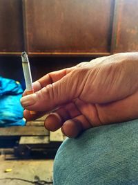 Close-up of hand holding cigarette