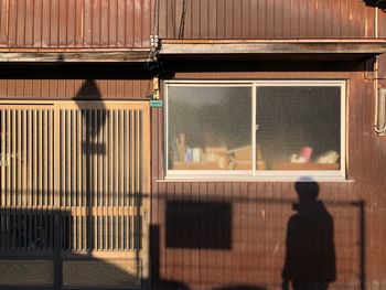 Shadow people on vintage house wall in evening light