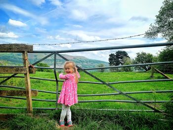 Full length of a girl standing against sky