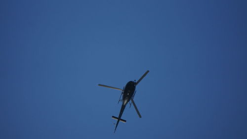 Low angle view of airplane against clear blue sky