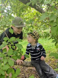 Boy looking at plants against trees