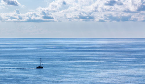 Sailboat sailing on sea against sky