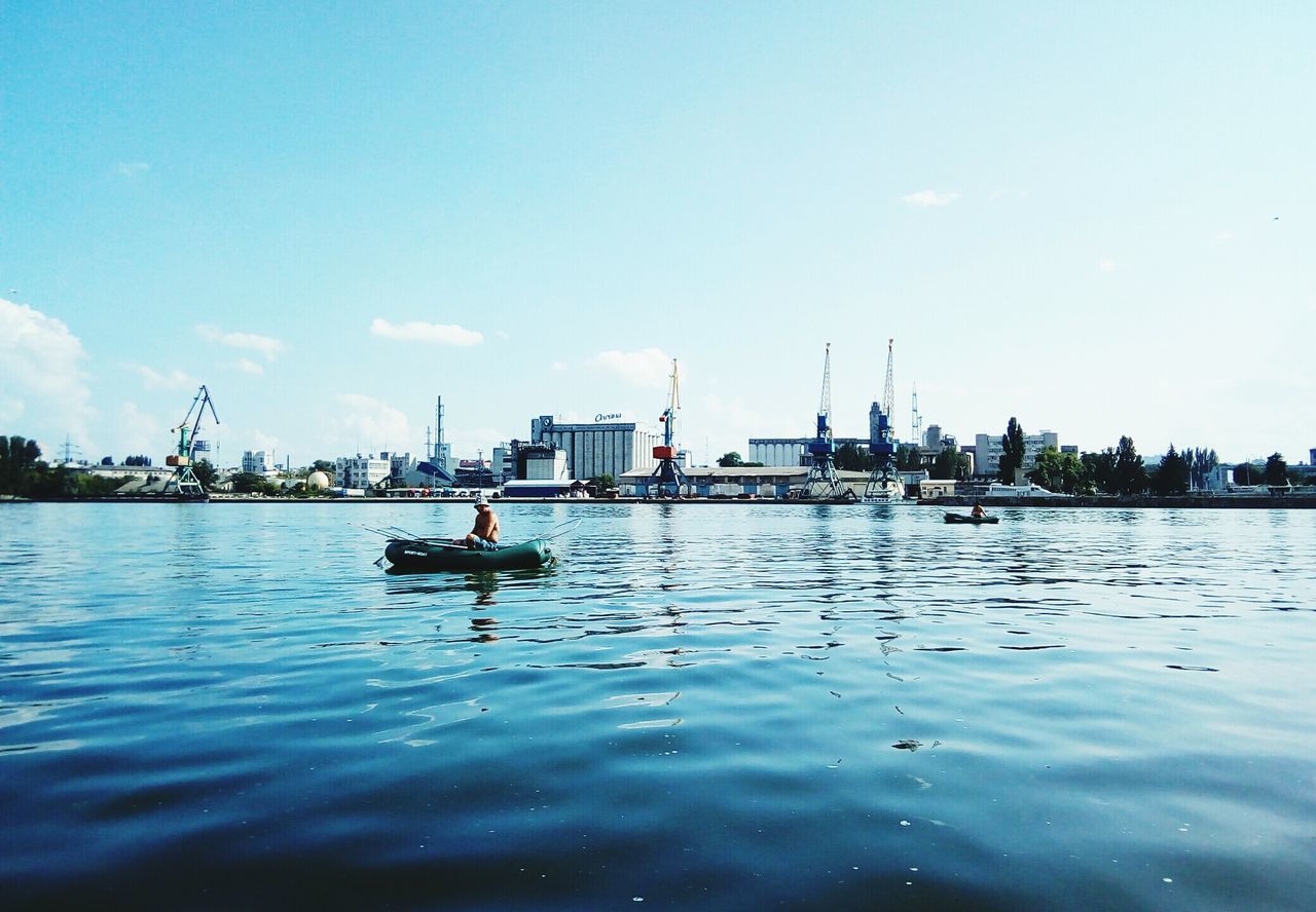 water, nautical vessel, transportation, waterfront, mode of transportation, sky, day, nature, cloud - sky, architecture, travel, sea, real people, men, built structure, building exterior, city, outdoors