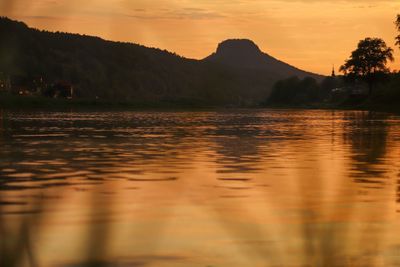 Scenic view of lake against orange sky