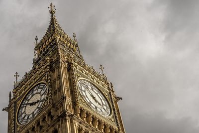 Low angle view of clock tower against cloudy sky