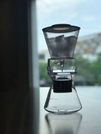 Close-up of coffee maker on table against window