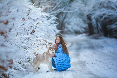 Portrait of young woman standing on snow covered field