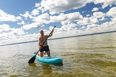 Man surfing in sea against sky