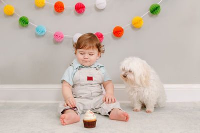 Happy smiling cute caucasian baby boy celebrating his first birthday at home. child kid toddler 