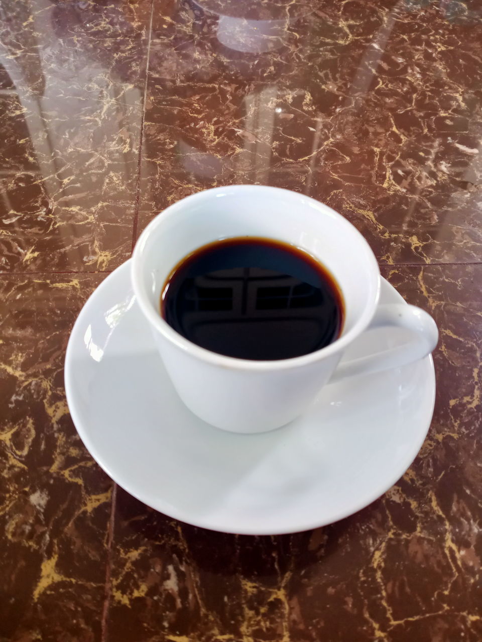 drink, food and drink, mug, cup, refreshment, coffee, coffee cup, crockery, saucer, caffè americano, table, black coffee, hot drink, high angle view, indoors, no people, freshness, spoon, food, close-up, still life, eating utensil