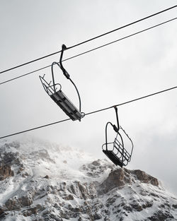 Low angle view of overhead cable car against sky