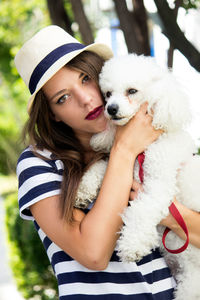 Close-up of woman with dog in hat