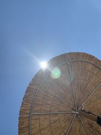 Low angle view of illuminated ferris wheel against blue sky