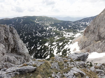 Scenic view of mountain range against cloudy sky