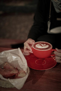 Man holding coffee cup on table