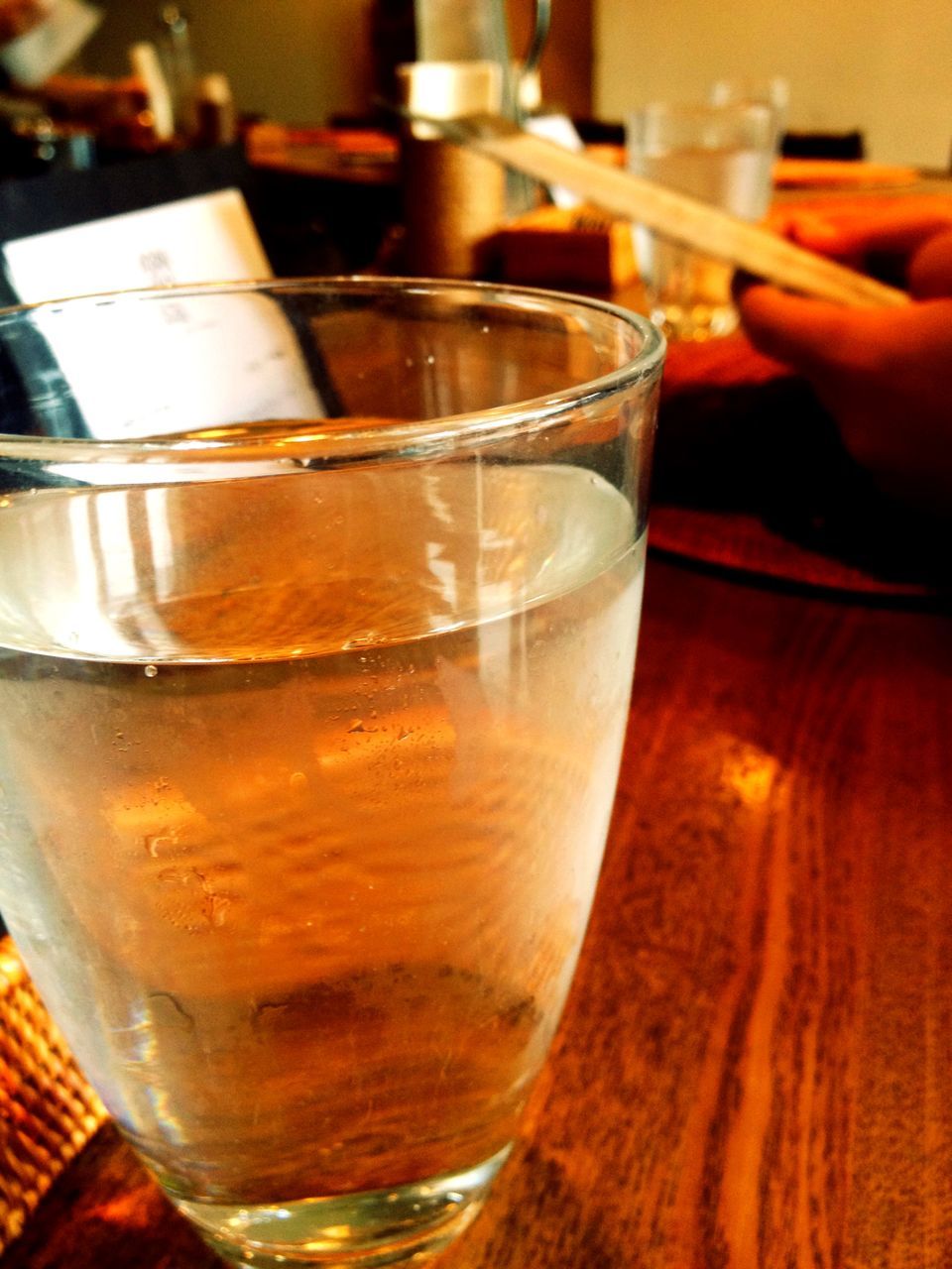 food and drink, indoors, drink, freshness, drinking glass, refreshment, table, close-up, food, still life, focus on foreground, person, glass - material, alcohol, healthy eating, one person, part of, cropped, restaurant, selective focus