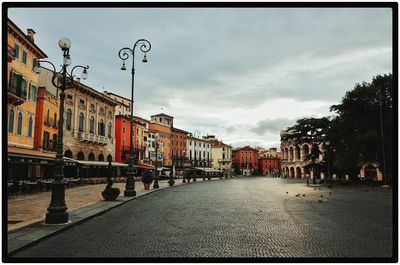 Buildings in city against cloudy sky