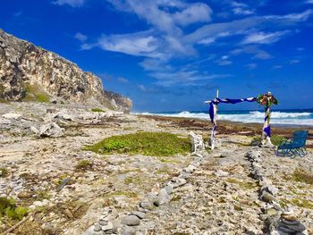 Scenic view of rocks on shore against sky