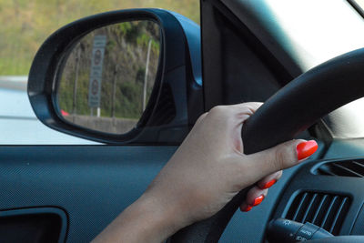 Cropped hand of woman driving car