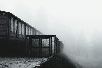 Scenic view of foggy weather against sky during winter