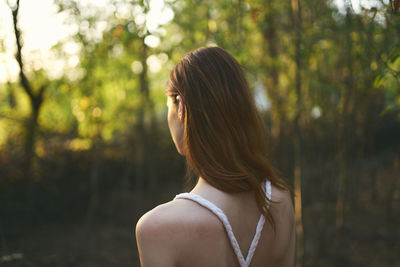 Rear view of woman against tree