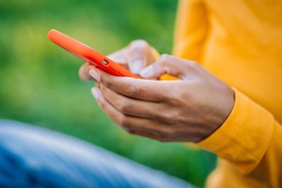 Close-up of woman holding orange leaf