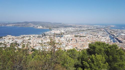 High angle view of townscape by sea against sky