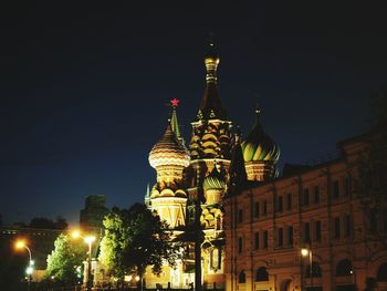 Low angle view of illuminated buildings against sky at night