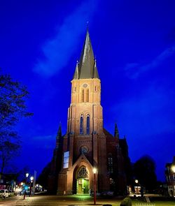 Low angle view of illuminated building against sky at night