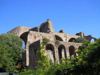 Low angle view of old ruin building against blue sky