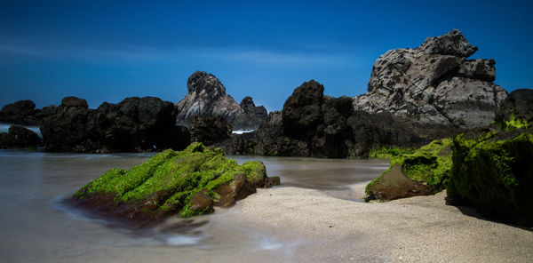 Scenic view of rocks in sea against sky