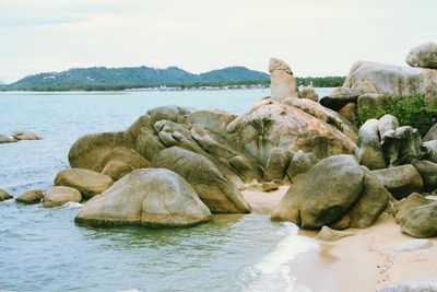 Rocks on sea shore against sky