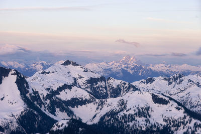 Scenic view of snowcapped mountains against sky during sunset