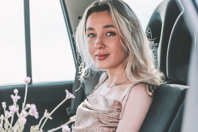 Young woman sitting in the car with flowers.