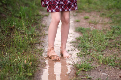 Low section of woman walking on field