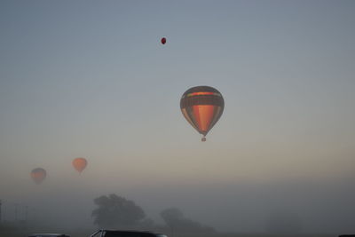 Hot air balloons flying against sky during sunset