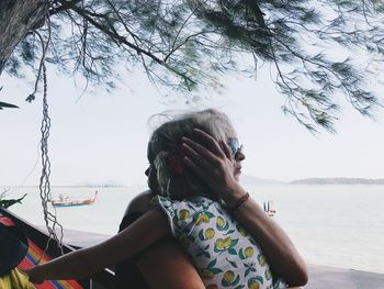 Portrait of woman standing by sea against sky