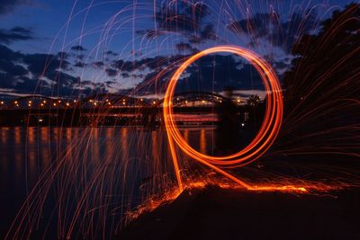 Light trails in city against sky at night