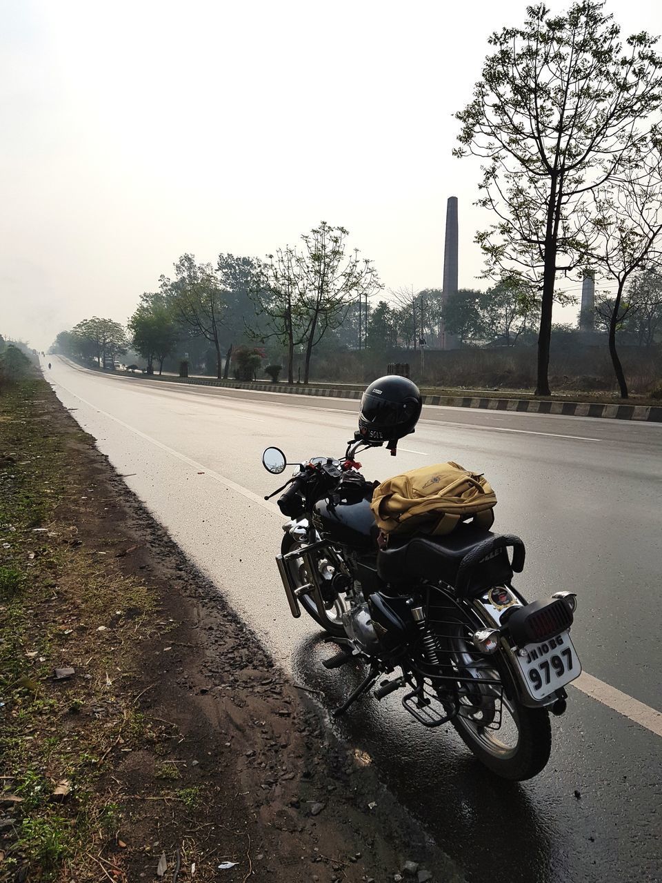 MAN RIDING MOTORCYCLE ON ROAD AGAINST CLEAR SKY