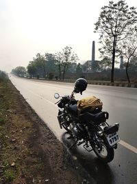 Man riding motorcycle on road against sky